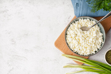 Bowl with tasty cottage cheese on light background