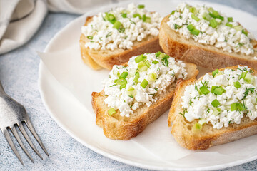 Sandwiches with tasty cottage cheese and green onion on grey background