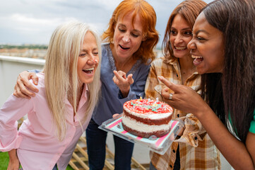 multiracial generational women friends with cake birthday fun