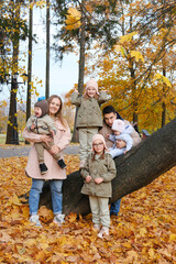 Fototapeta premium Large family posing in the autumn park. The family consists of mother, father and four children.