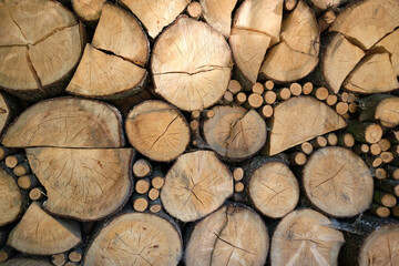 Stacked large and small, chopped and round firewood in a pile. Close-up of a woodpile of fire logs wood prepared for a cold winter. Natural solid fuel. Czech Republic. Europe.