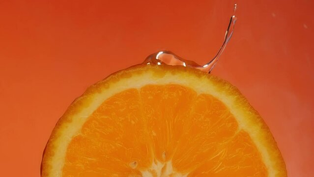 Juicy Orange. Water dripping on an orange slice. Slice of orange. Squeeze out juice.