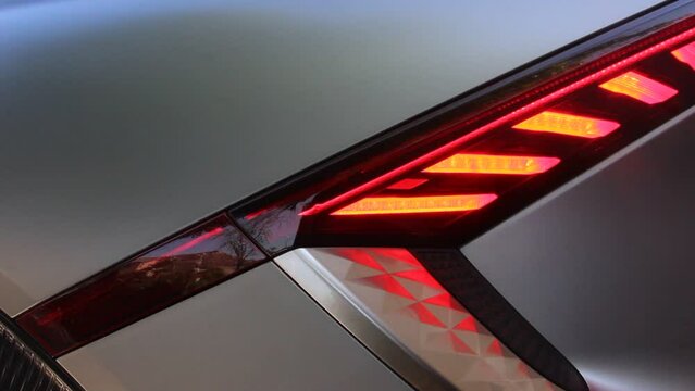 Video of red flashing LED lights of modern electric car. 