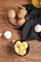 Fototapeta premium Boiled and raw potatoes on wooden background