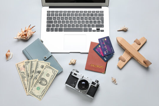 Composition with credit cards, modern laptop, money and wooden plane on white background