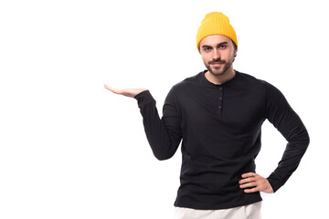 young brunette European brutal man in a black sweatshirt shows his hand at the wall