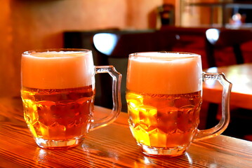 2 glasses of beer with thick foam in a restaurant, bar, brewery, Prague, Czech Real amber beer in...