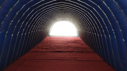 interior view of inflatable tunnel to go out to sports stadium, light at the end of the tunnel