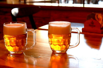 2 glasses of beer with thick foam in a restaurant, bar, brewery, Prague, Czech Real amber beer in mugs, pint