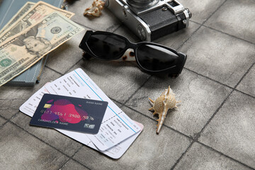 Naklejka premium Credit card, tickets, sunglasses and money on grunge tile background