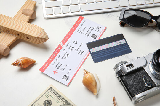 Composition with ticket, credit card, photo camera and wooden plane on light background