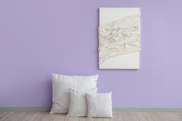 White pillows and painting near lilac wall