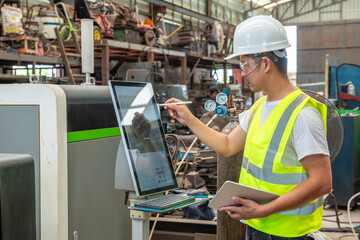 a civil engineer man using laser cutting machine with his tablet on hand