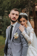 European wedding couple in the park near the stairs. The bride in a beautiful dress with a long...