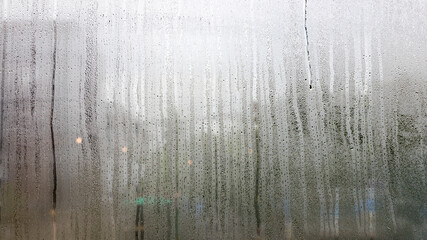 Misted glass, silver rain drops dew drops on transparent glass window. Wet misted glass with drops...