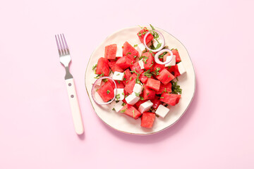 Plate of tasty watermelon salad on pink background