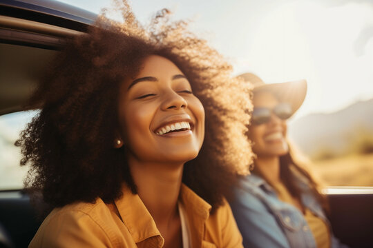 Cheerful African American woman leans out of the car window, enjoying the sun