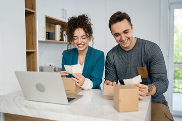 couple woman and man open presents and read card while on video call