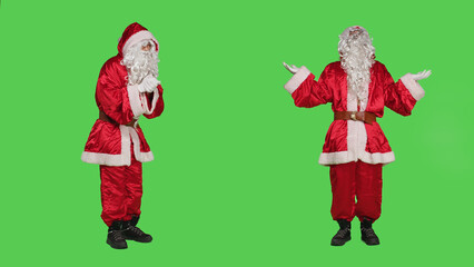 Santa claus praying to god with hands in a prayer, posing over full body greenscreen in studio....