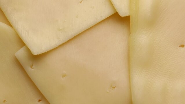 light yellow cheese slices, rotation in circle. yellow cheese slice (gouda), Turning. selective focus.