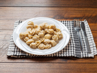 Big portion of Russian dumplings on a white plate. Tasty dinner. Classic west European dish.