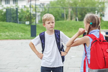 Two children, classmates, quarrel and yell on way from school. Conflict and negative emotion. - obrazy, fototapety, plakaty
