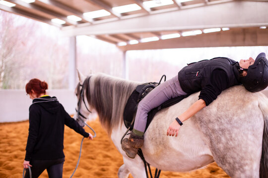 Hippotherapy. Therapeutic wellness, occupational therapy mid-adult woman patient on horse school