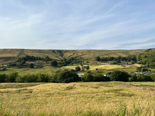 Evening country landscape, with wild grasses, trees, farms, and distant hills near, Manchester Road, Marsden, UK