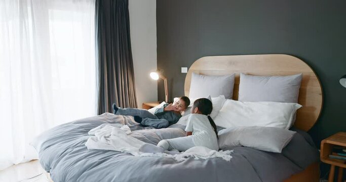 Happy, bed and children jumping in the morning for energy, crazy and funny together in a home. Smile, young and excited kids, siblings or friends in the bedroom with joy, comic and friendship