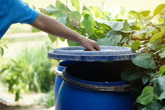 Closeup hand hold lid to cover water bucket to protect from mosquito to breed inside or other  insects or dust go into water. Concept, campaign to stop mosquitoes cycle to lay eggs in water container 