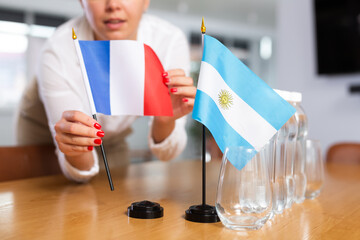 Little flag of Argentina on table with bottles of water and flag of France put next to it by...