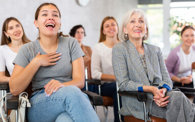 Obraz premium group of female students in lecture hall is sitting and having fun together over joke of tutor. Professor-student interaction, productive learning