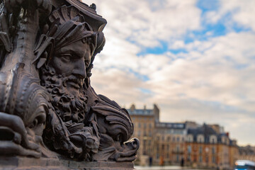 Cast iron decorative ornament with human face, lantern on a bridge in Paris, France