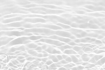 White water with ripples on the surface. Defocus blurred transparent white colored clear calm water surface texture with splashes and bubbles. Water waves with shining pattern texture background.