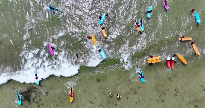 Top view of the beach with surfers practising their wave 4k
