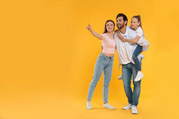 Fototapeta premium Happy family on orange background, space for text