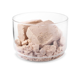 Pieces of compressed yeast in glass jar isolated on white