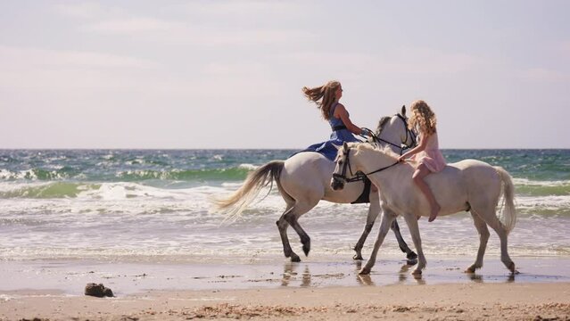Girls Riding White Horses At The Beach