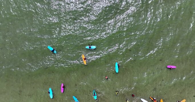 Top view of the beach with surfers practising their wave 4k