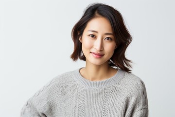 Fototapeta premium Portrait of a beautiful young asian woman smiling over white background