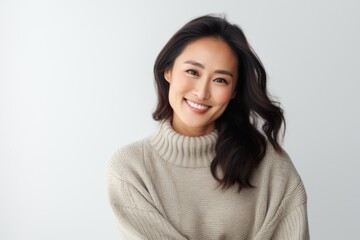 Fototapeta premium Portrait of a smiling asian woman looking at camera over white background