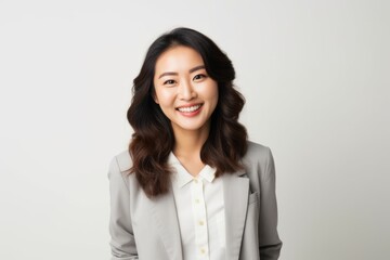 Portrait of a smiling asian businesswoman standing against white background