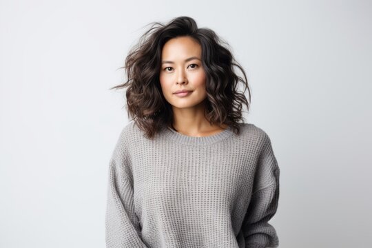 Portrait of a beautiful young asian woman in sweater on white background