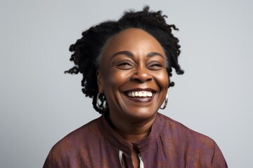 Obraz premium Portrait of a happy african american woman laughing over gray background