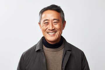 Obraz premium Portrait of a happy mature asian man smiling over white background