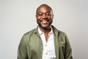 Fototapeta premium happy african american man in green shirt smiling at camera isolated on grey