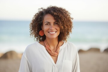 Portrait of a smiling young woman with earphones on the beach