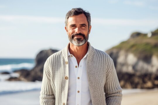Portrait of a handsome mature man standing on the beach at the day time