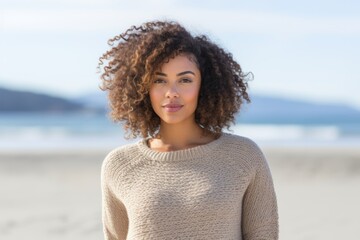 Portrait of a beautiful young woman with curly hair on the beach