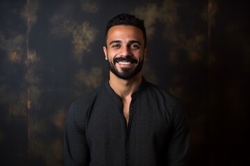 Obraz premium Portrait of a handsome young man smiling at the camera on a dark background